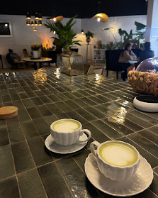 Matcha latte servi chez Café Fleurs sur table en carrelage vert